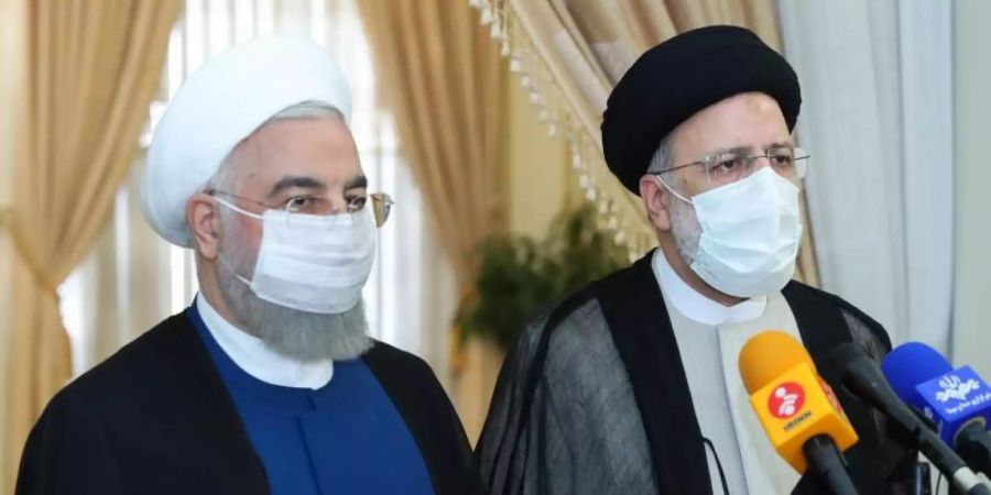 Der scheidende iranische Präsident Hassan Ruhani (l) tritt mit seinem gewählten Nachfolger Ebrahim Raeissi vor die Presse. Foto: -/Iranian Presidency/dpa