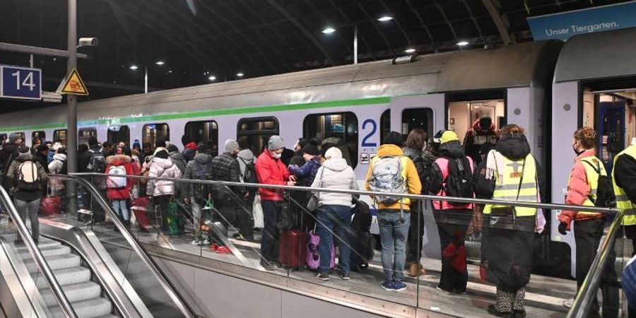 Geflüchtete Meneschen aus dem ukrainischen Kriegsgebiet stehen nach ihrer Ankunft am Berliner Hauptbahnhof. Foto: Paul Zinken/dpa