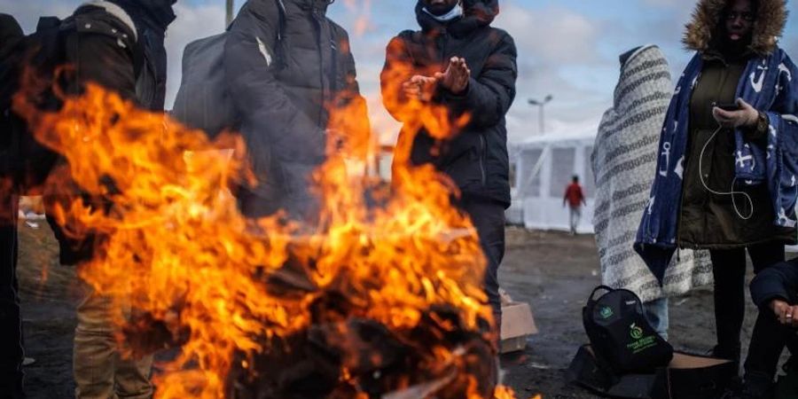 Mehrere Menschen wärmen sich an einem Feuer am Grenzübergang zwischen Polen und der Ukraine. Foto: Alejandro Martínez Vélez/EUROPA PRESS/dpa