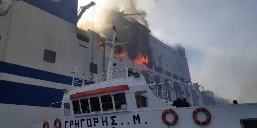 Ein Schiff nähert sich der brennenden Autofähre «Euroferry Olympia» vor Korfu. Einer Spezialeinheit des griechischen Rettungsdienstes ist es gelungen, zwei Männer zu retten. Foto: Uncredited/Hellenic Fire Service/AP/dpa