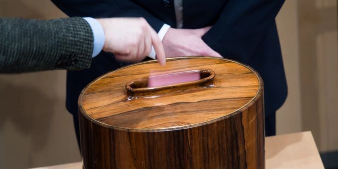 Ein Abgeordneter wirft während der Abstimmung im Rahmen einer Sitzung des Nationalrates im Parlamentsausweichquartier in der Wiener Hofburg seinen Stimmzettel ein. Österreich führt eine allgemeine Impfpflicht zur Bekämpfung der Corona-Pandemie ein. Foto: Michael Gruber/APA/dpa Ein Abgeordneter wirft während der Abstimmung im Rahmen einer Sitzung des Nationalrates im Parlamentsausweichquartier in der Wiener Hofburg seinen Stimmzettel ein. Österreich führt eine allgemeine Impfpflicht zur Bekämpfung der Corona-Pandemie ein. Foto: Michael Gruber/APA/dpa
