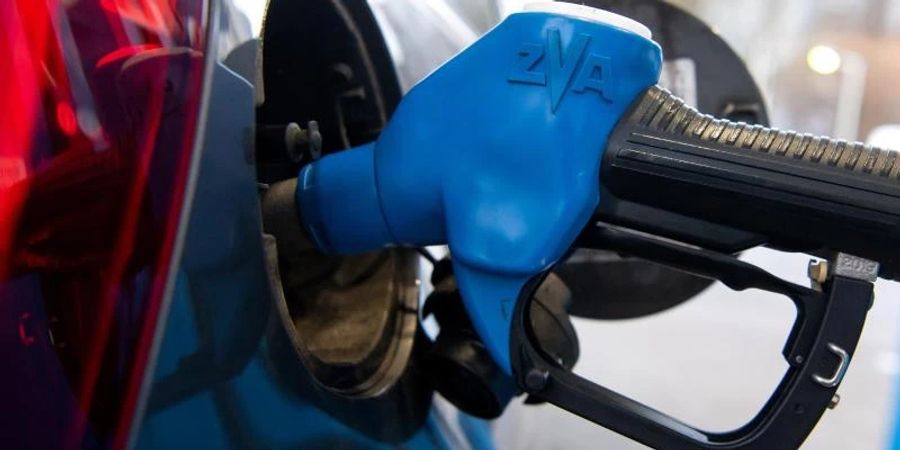 Eine Zapfpistole steckt an einer Tankstelle in der Tanköffnung eines Fahrzeugs. Foto: Sven Hoppe/dpa