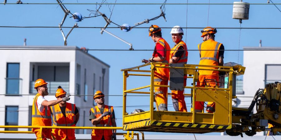 Arbeiter reparieren die abgerissene Oberleitung. Im Münchener Hauptbahnhof standen an fast allen Gleisen Züge auf unbestimmte Dauer still.