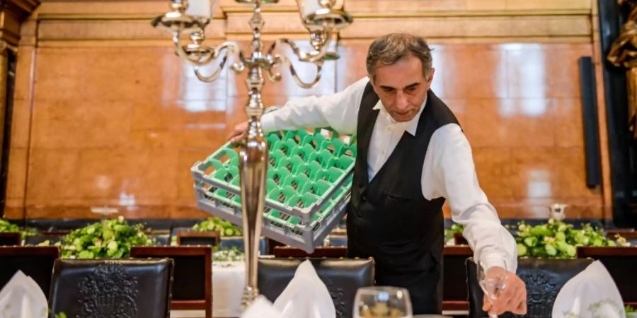 Ein Kellner deckt einen Tisch