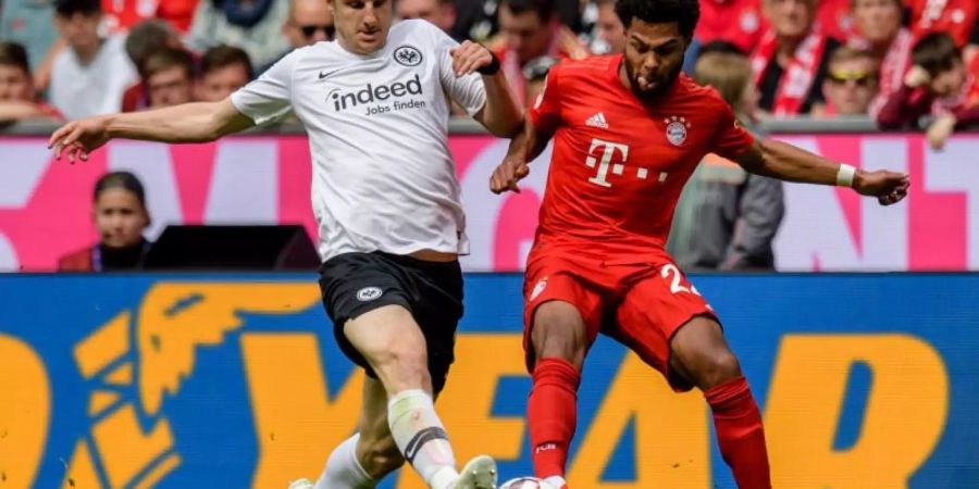 Martin Hinteregger von Frankfurt (l) liefert sich mit Bayern-Spieler Gnabry einen Zweikampf. Foto: Matthias Balk