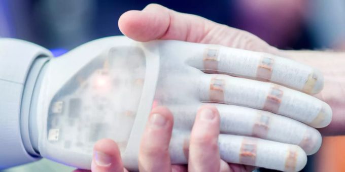 Eine Roboterhand hält die Hand eines Menschen. Künstliche Intelligenz