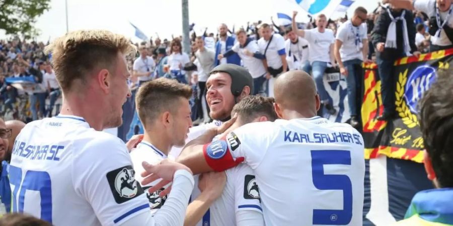 Spieler und Fans des Karlsruher SC jubeln nach dem 4:0 gegen Preussen Münster. Foto: Friso Gentsch