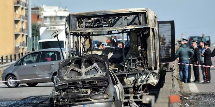 Die ausgebrannten Wracks des Busses und eines Autos