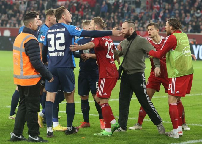 Düsseldorf-Spieler versuchen einen Chaoten vom Feld zu bringen. düsseldorf