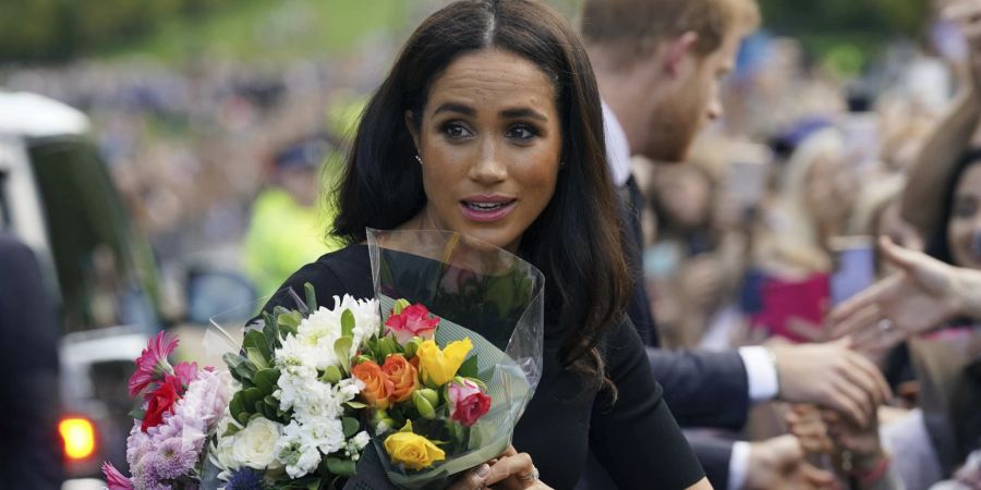 Meghan Markle hält Blumen für die Queen.