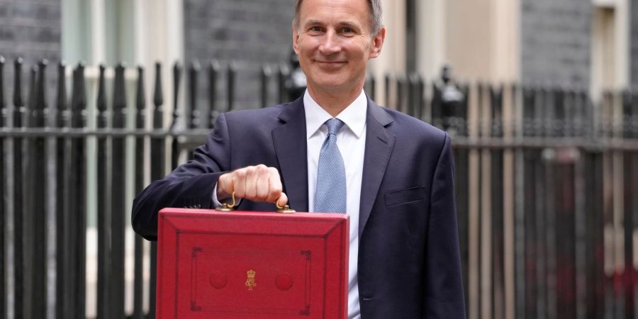 Jeremy Hunt, Finanzminister von Grossbritannien, zeigt vor 11 Downing Street seinen roten Aktenkoffer, bevor er seinen Haushaltsplan im Parlament vorstellt.