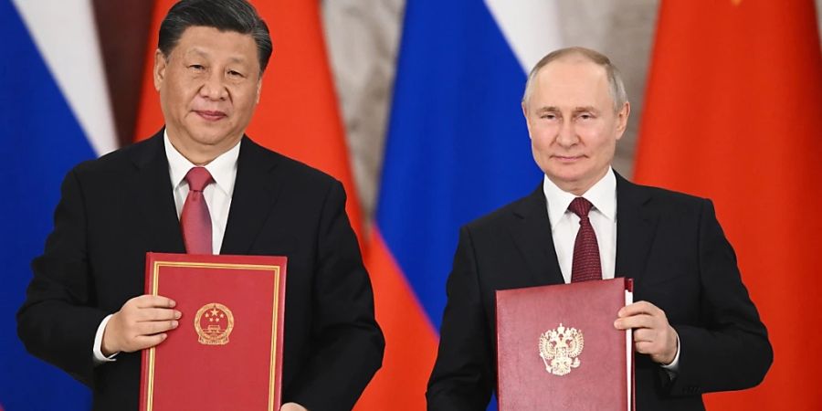 Wladimir Putin (r), Präsident von Russland und Xi Jinping, Präsident von China, zeigen Mappen mit den Verträgen während einer Unterzeichnungszeremonie im Anschluss an ihre Gespräche im Grossen Kremlpalast. Foto: Vladimir Astapkovich/Sputnik Kremlin Pool via AP/dpa