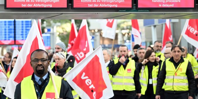 Streikende Mitarbeiter stehen mit Verdi-Flaggen im Terminal des Flughafens Düsseldorf. Streikende Mitarbeiter stehen mit Verdi-Flaggen im Terminal des Flughafens Düsseldorf.