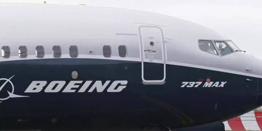 Ein Pilot winkt aus der Pilotenkabine eines Flugzeuges vom Typ Boeing 737 MAX auf dem Flughafen. Foto: Ted S. Warren/AP/dpa