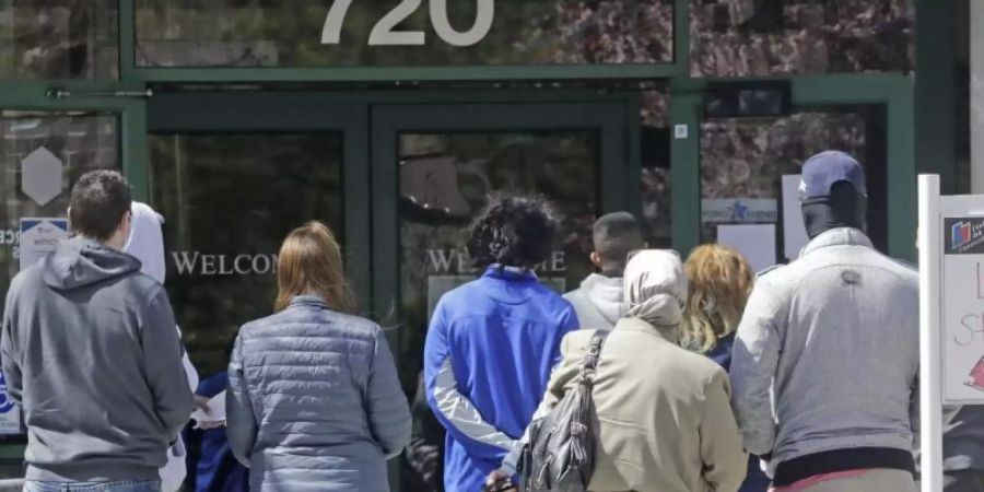 Menschen warten vor einem Arbeitsamt in Salt Lake City. Foto: Rick Bowmer/AP/dpa