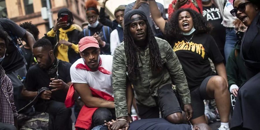 Demonstranten stellen in New York die Szene nach, die zum Tod von George Floyd führte. Der Protest der Demonstranten richtet sich gegen Rassismus und Polizeigewalt. Foto: Wong Maye-E/AP/dpa