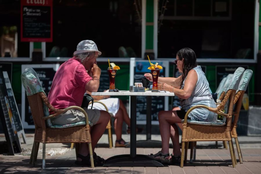 Deutsche Touristen sitzen im Aussenbereich einer Bar am Strand von Palma de Mallorca. Foto: Joan Mateu