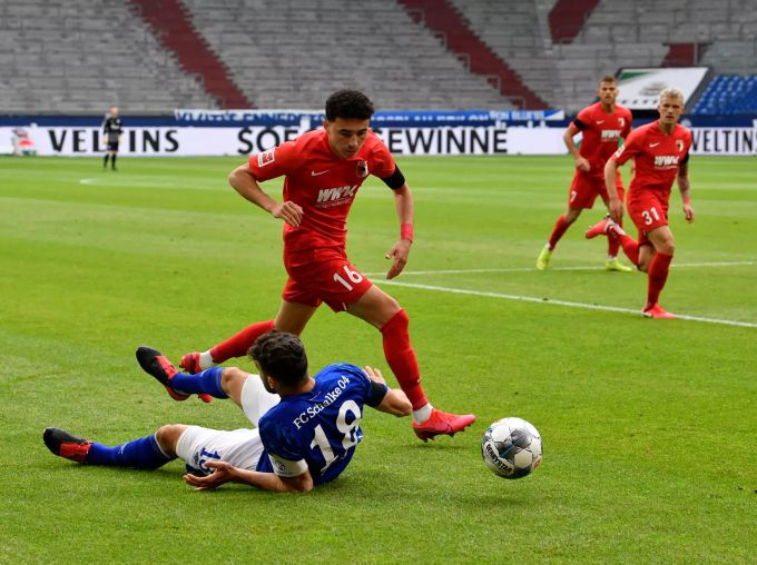 Daniel Caligiuri von Schalke (unten) und Ruben Vargas vom FC Augsburg kämpfen um den Ball. FC Augsburg