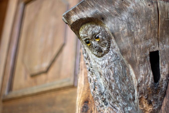 Eine geschnitzte Holz-Eule wacht über den Platz.