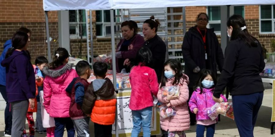 Kinder stehen an einer Essensausgabe an