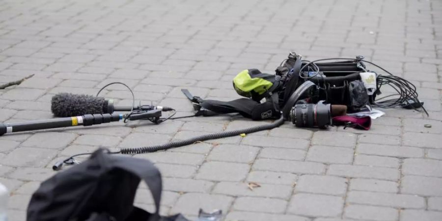 Die Ausrüstung eines Kamerateams liegt nach einem Überfall auf ein ZDF-Teams zwischen Alexanderplatz und Hackescher Markt auf dem Boden. Foto: Christoph Soeder/dpa