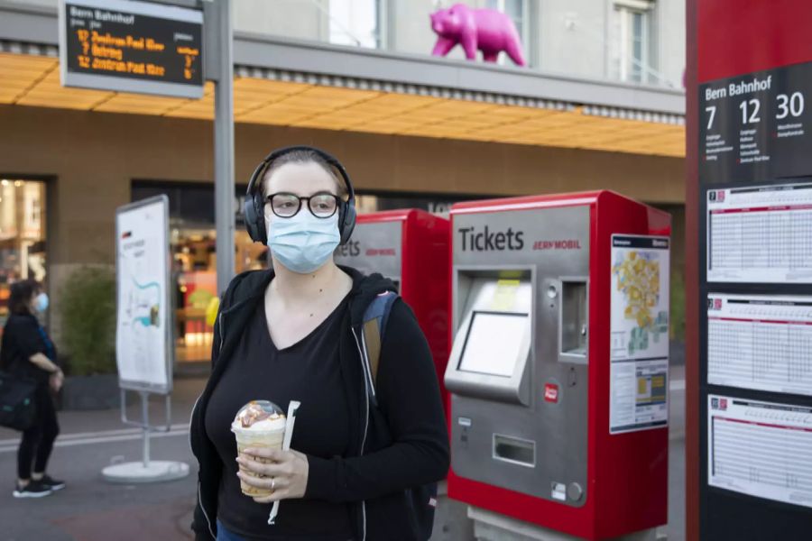 Eine Frau steht am Bahnhof Bern vor zwei Billettautomaten von Bernmobil.