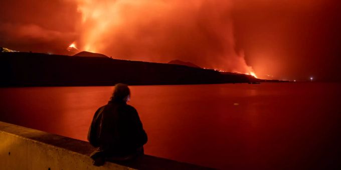 Eine Person steht am Strand von Los Guirres und beobachtet, wie Lava während des Ausbruchs des Vulkans Cumbre Vieja auf La Palma auf den Kanarischen Inseln ausströmt. la palma