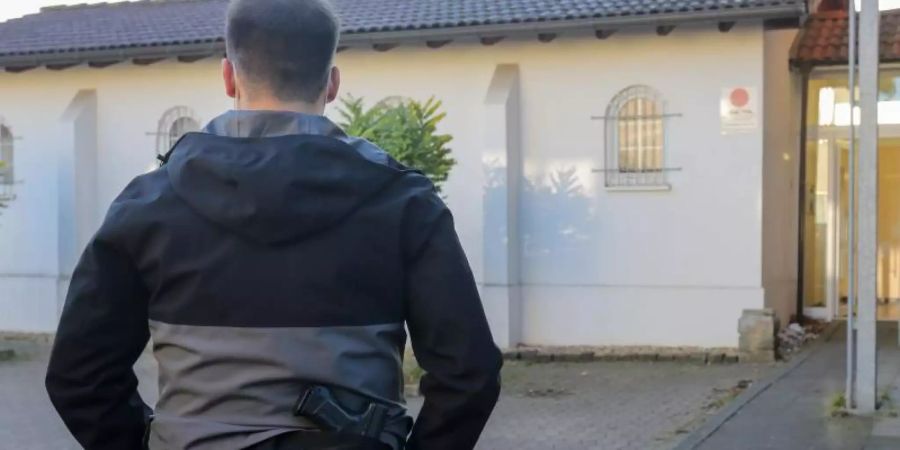 Ein Polizeibeamter sichert einen Einsatzort in Düren. Foto: Ralf Roeger/dpa