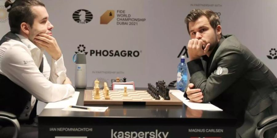 Magnus Carlsen (r) und Jan Nepomnjaschtschi zu Beginn der ersten WM-Partie. Foto: Kamran Jebreili/AP/dpa