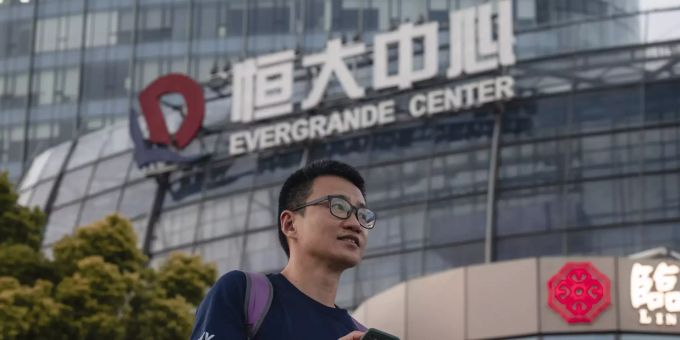 Ein Mann steht vor dem Evergrande Center in Shanghai. Evergrande center in Shanghai