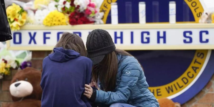 Menschen trauern vor der Oxford High School. Foto: Paul Sancya/AP/dpa