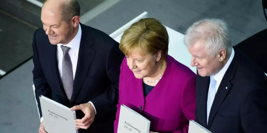 Kanzlerin Merkel, CSU-Chef Seehofer (r) und der damalige kommissarische SPD-Vorsitzende Scholz präsentieren den Koalitionsvertrag. Foto: Gregor Fischer/dpa