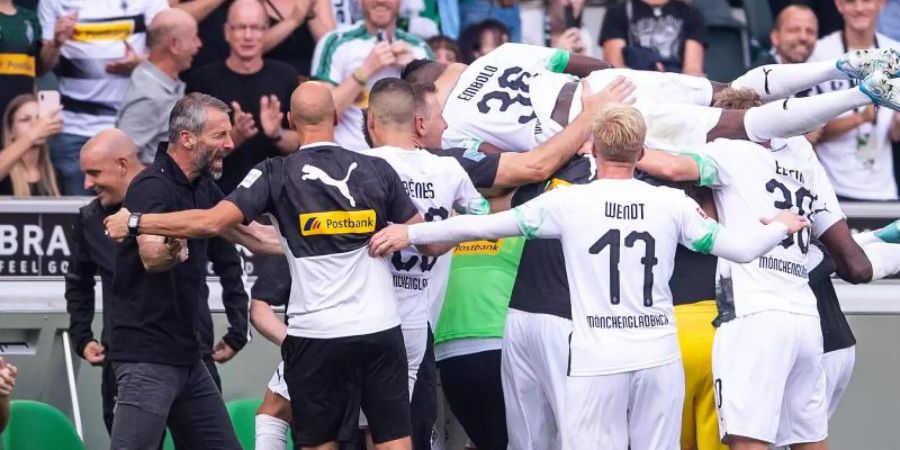 Marco Rose (2.v.l.) und seine Gladbacher bejubeln den Sieg gegen Düsseldorf. Foto: Marius Becker