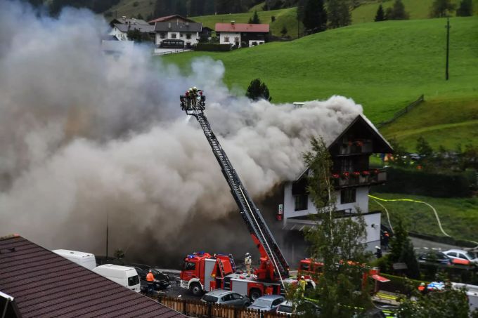 Feuerwehrleute löschen einen Brand in einem Haus. Bei einer Explosion in einem Gebäude in Tirol sind nach ersten Erkenntnissen neun Menschen verletzt worden. Tirol