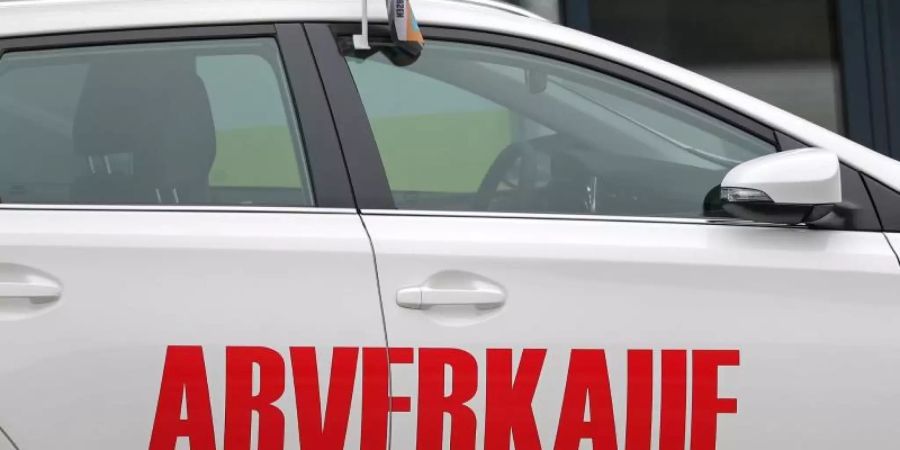 Der Schriftzug «Abverkauf» steht auf einem weissen Toyota vor einem Autohaus. Foto: Jan Woitas/zb/dpa