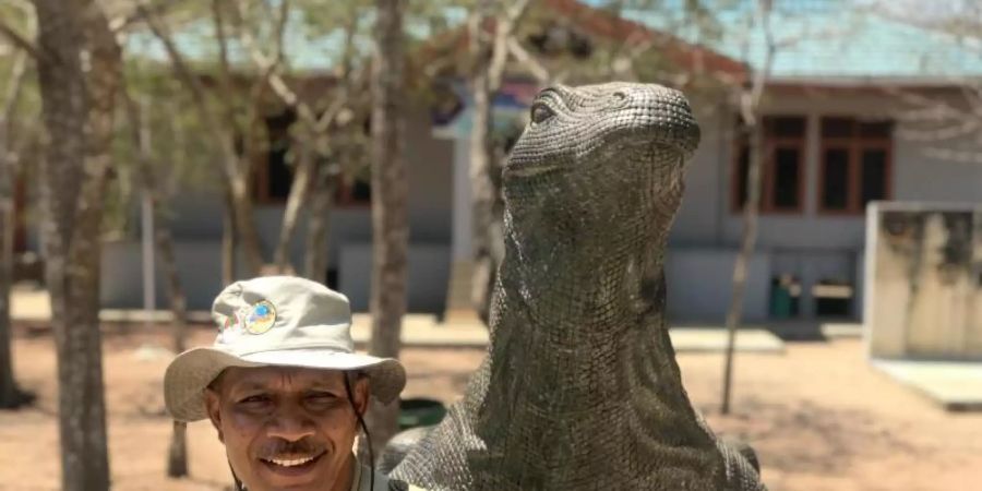 Chef-Ranger Johanes Rawineben einem Drachen-Denkmal im Nationalpark von Komodo. Foto: Christoph Sator/dpa