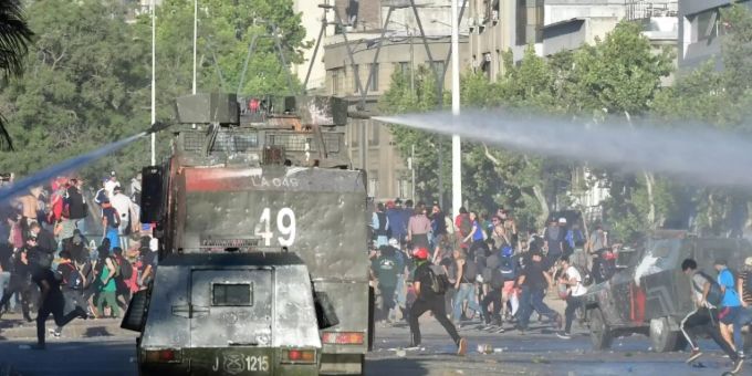 Wasserwerfer gegen Demonstranten in Santiago de Chile. Wegen der Ausgangsperre sind viele Menschen in Chile von der Existenz bedroht. Coronavirus