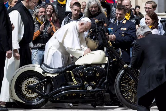 Papst Franziskus ist für sein unkompliziertes Verhalten sehr beliebt. So siginiert er etwa ohne Umschweife den Tank einer Harley Davidson. papst franziskus