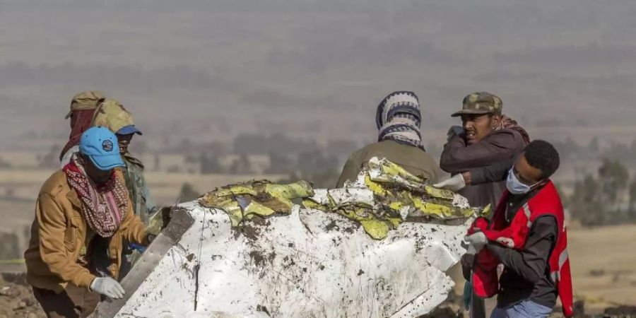Rettungskräfte arbeiten an der Absturzstelle des Fluges 302 der Ethiopian Airlines vom Typ Boeing 737 Max 8 in der Nähe von Bishoftu, südlich von Addis Abeba. Foto: Mulugeta Ayene/AP/dpa