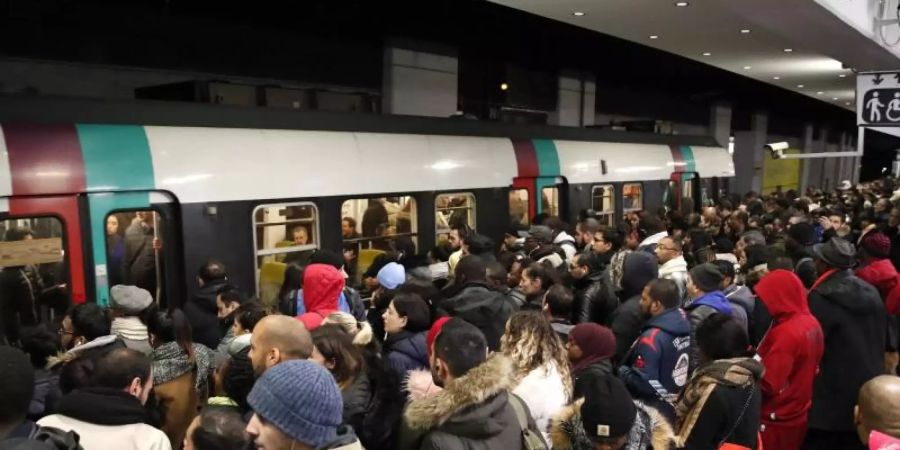 Pendler in Paris warten darauf, eine U-Bahn zu erwischen. Foto: Francois Mori/AP/dpa