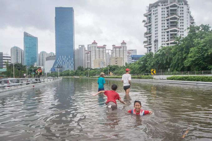 Kinder spielen auf einer überfluteten Autobahn in Jakarta. Überschwemmungen in Indonesien