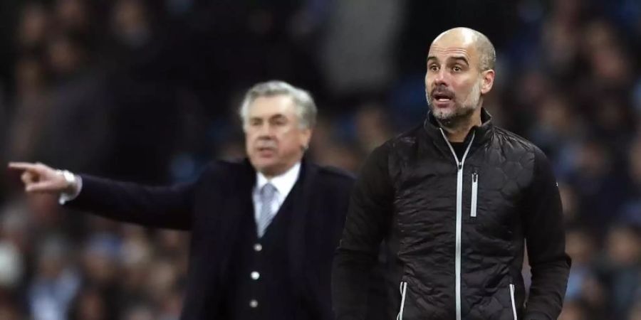 Carlo Ancelotti (l) und Pep Guardiola. Foto: Martin Rickett/PA Wire/dpa