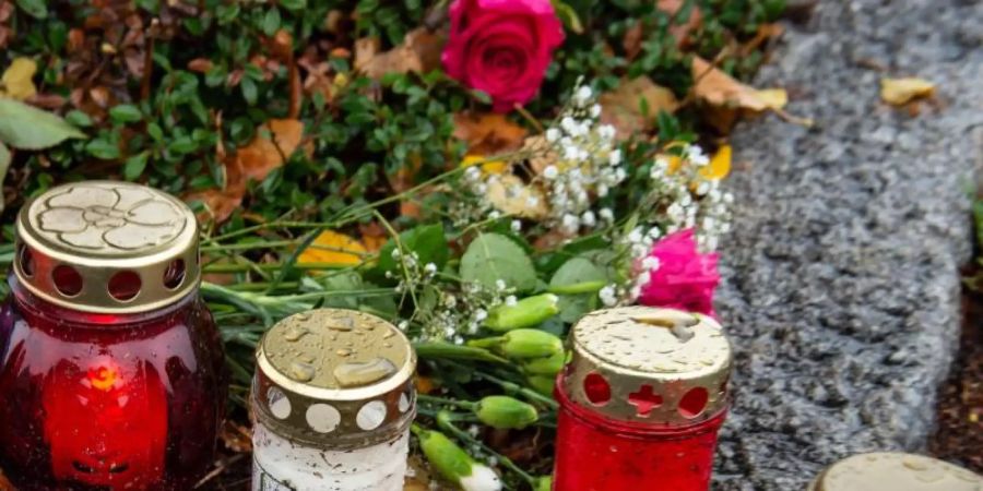Nahe dem Tatort in Göttingen haben Menschen Kerzen und Rosen niedergelegt. Foto: Swen Pförtner