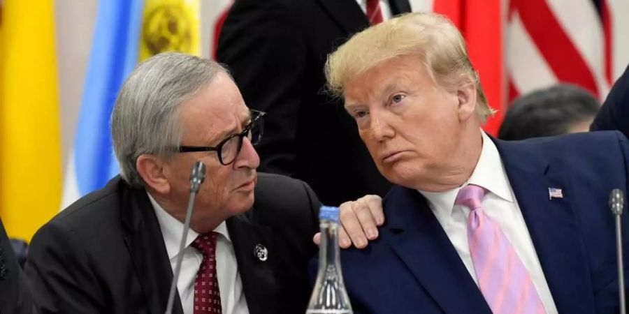Jean-Claude Juncker (l.) beim vergangen G20-Gipfel in Osaka, Japan, im Gespräch. Der scheidende EU-Kommissionspräsident Juncker cglaubt nicht, dass US-Präsident Trump neue Autozölle erhebt. Foto: Susan Walsh/AP/dpa/Archiv
