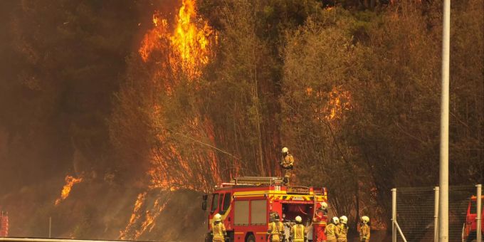 Feuerwehreinheiten bekämpfen Ende November die Flammen, die am Rande einer Landstrasse aus dem Wald steigen bei Valparaiso. Waldbrand in Chile