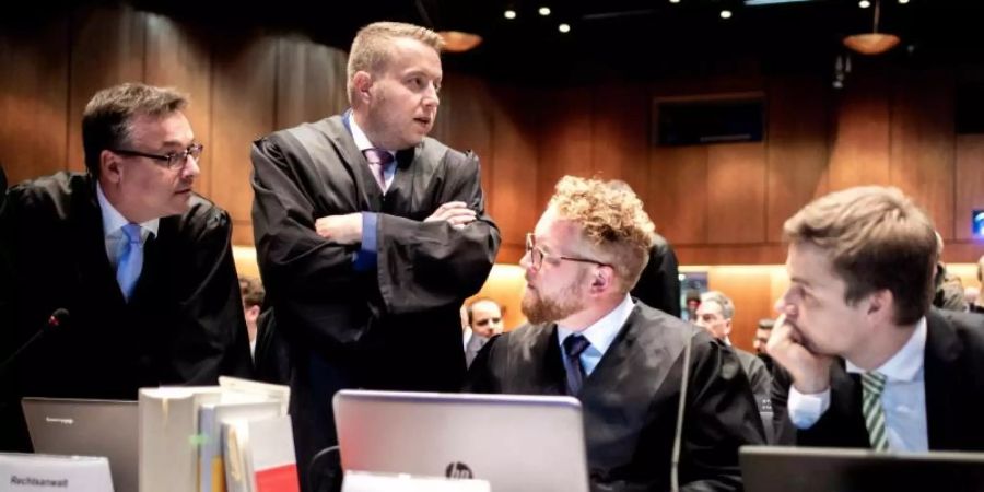 Anwälte und Prozessbeteiligte unterhalten sich vor Beginn der mündlichen Verhandlung zur Musterfeststellungsklage des Bundesverbands der Verbraucherzentralen und Verbraucherverbände gegen VW. Foto: Hauke-Christian Dittrich/dpa
