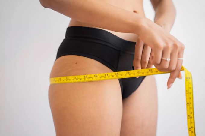 Abnehmen ist nicht leicht. Frau misst sich mit Massband