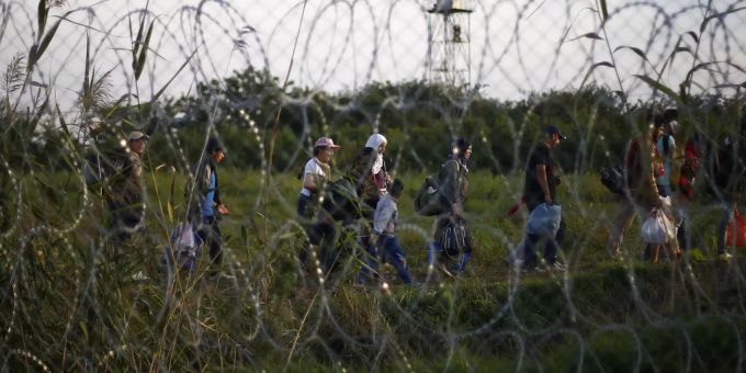 Migranten gehen am Grenzzaun zwischen Ungarn und Serbien entlang. migration asyl ungarn