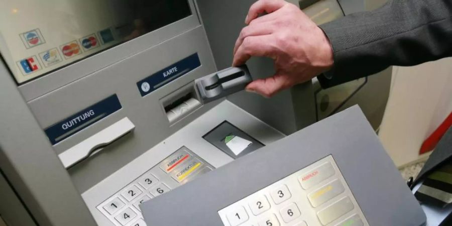 Ein Mitarbeiter der Sparkasse Koblenz demonstriert an einem Geldautomaten die «Skimming»- Technik. Foto: Thomas Frey/dpa