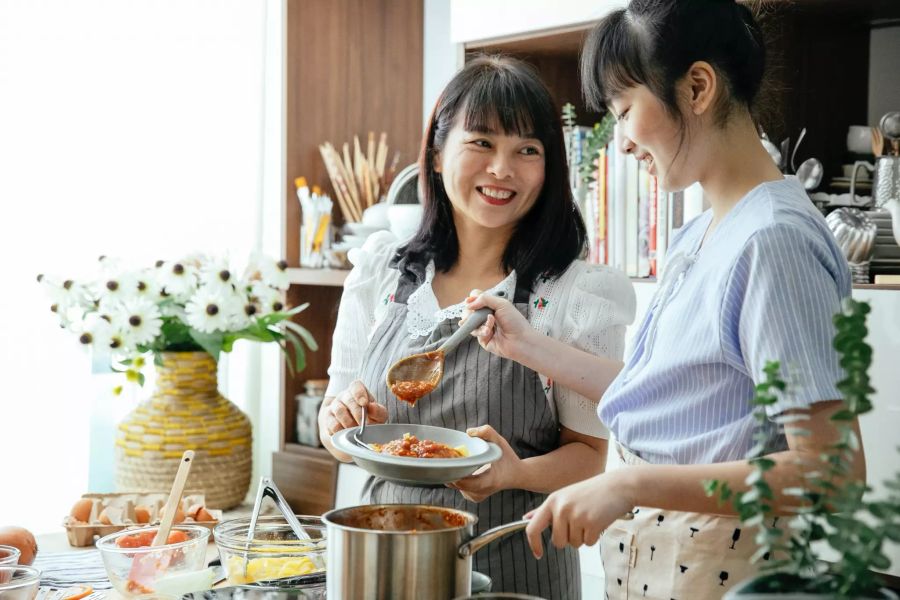 Zwei Frauen kochen.